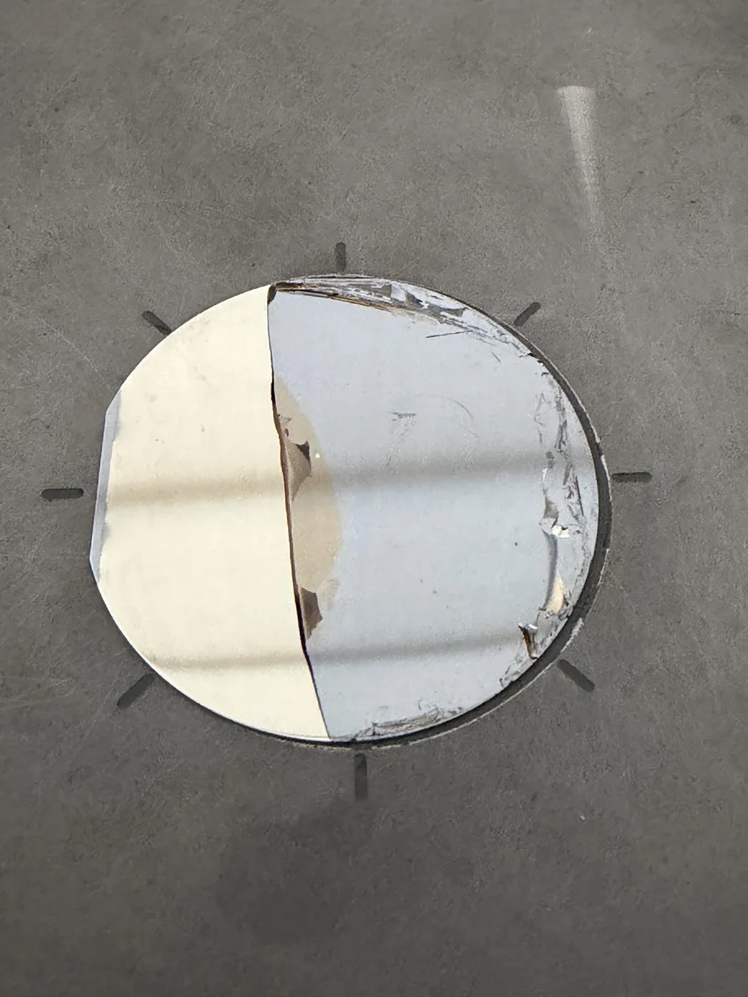 A 2-inch wafer where the nickel film has partly lifted away, exposing a mirror-finish release plane